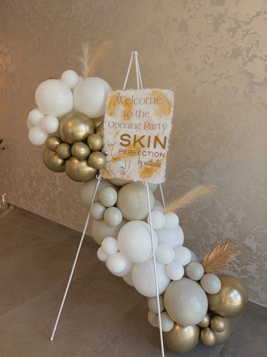 Willkommensschild mit Ballons in Weiss und Gold an einer Eröffnung