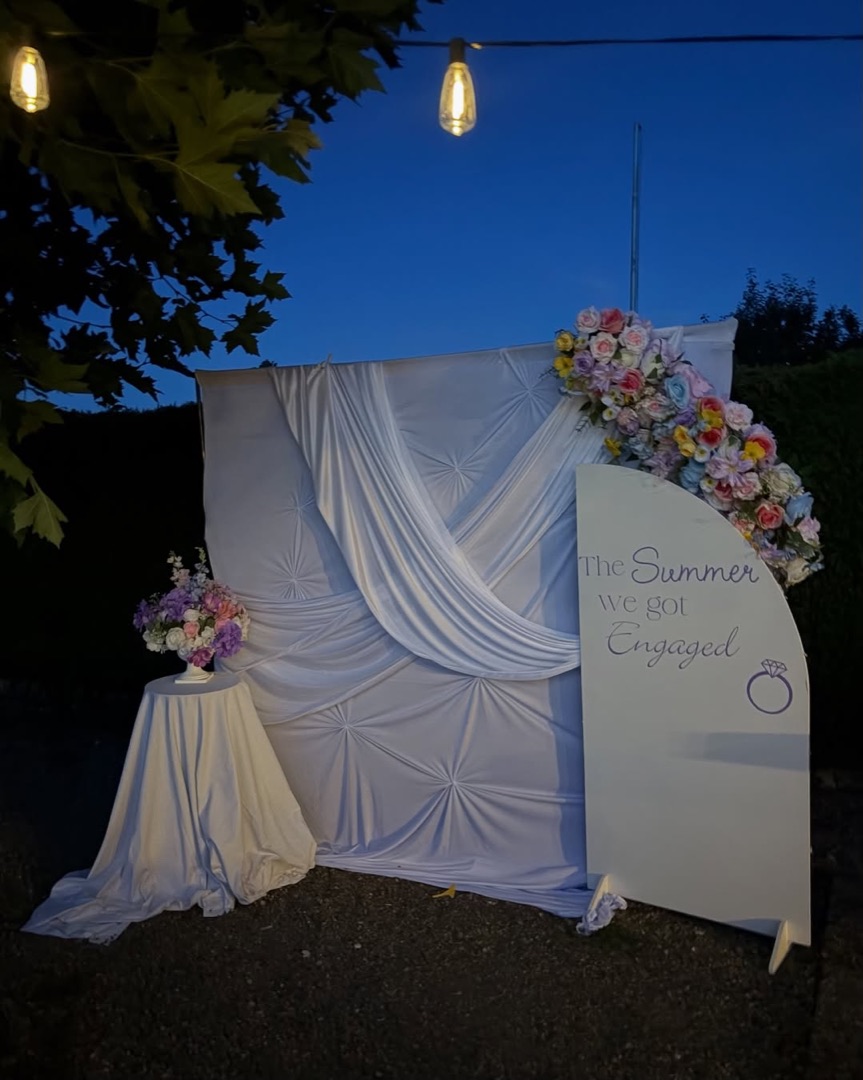 Verlobungsdeko am Abend mit Blumen und hellem Tuch